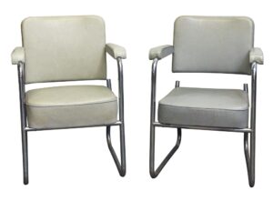 Pair of gray vinyl office arm chairs with chrome-finished steel frames, shown front-facing side by side.