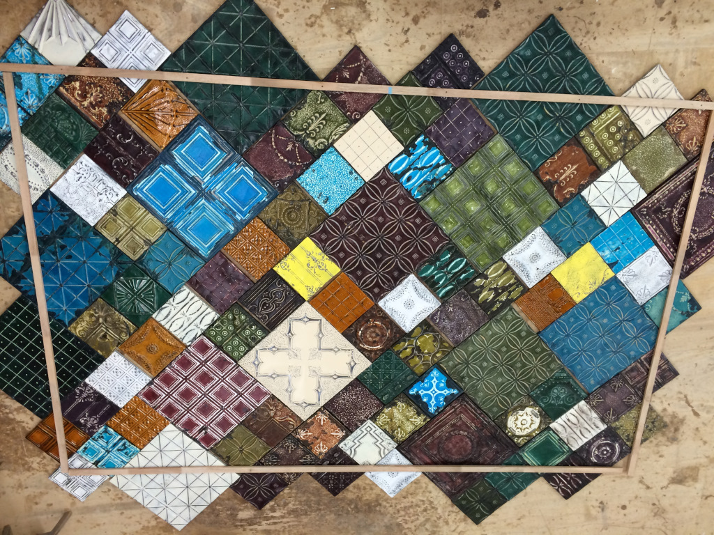 Ceiling tin of all shapes, colors and sizes can be created by you! Colorful, patterned ceramic tiles from Olde Good Things are set in a diamond arrangement on a tan background with wooden borders on all sides. Each tile has unique colors and designs.