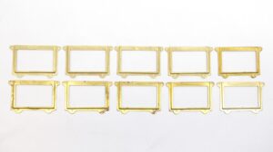 Set of 10 polished brass rectangular drawer label slots arranged in two rows on a white background.
