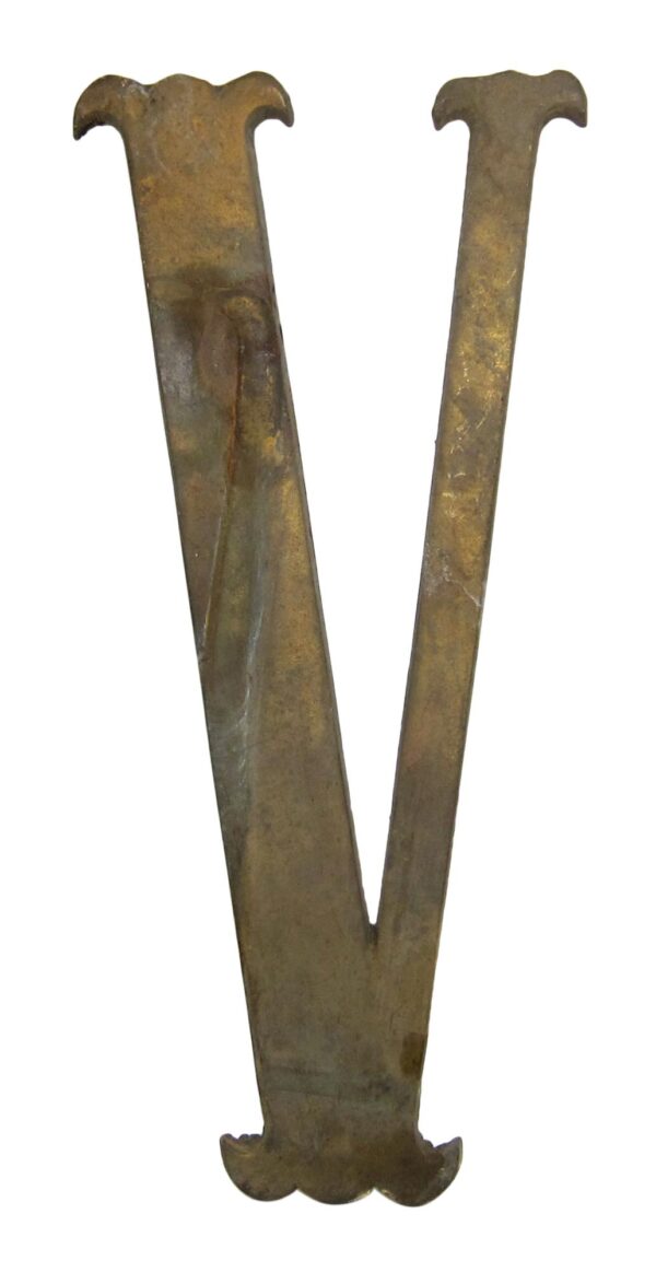 Antique brass letter V made of brass, shown upright with visible wear.