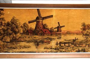 Framed fabric wall art showing a Holland windmill scene with water, trees, and small buildings in a wood frame.