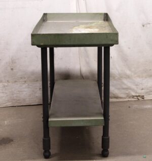Two-tier industrial table with a green metal top, black metal legs, and a lower shelf, shown from the front.