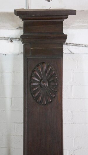 Dark wood tone wainscot panel with a carved oval rosette and stepped top molding.