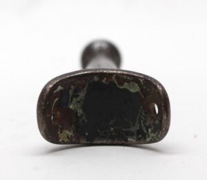 Vintage cast iron wardrobe hook with a rounded back and single hook opening, shown from the front with mounting holes visible.