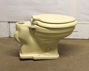 1950s light yellow ceramic toilet with matching lid and seat, shown in side view without a tank.