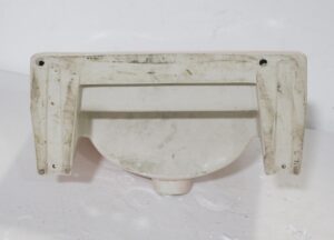 Vintage 1950s pink porcelain sink shown from the underside, with mounting holes and a rounded trapezoid bowl shape visible.