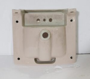 Pale pink porcelain sink shown from above with a rounded trapezoid bowl, three faucet holes, and mounting holes at the corners.