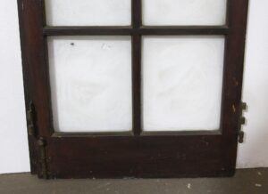 Dark wood tone French door with ten window panes and an attached lip, shown front view with hinges visible on both sides.