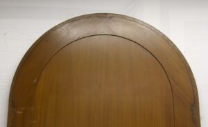 Arched mahogany wood panel section with a dark wood tone and curved top edge.