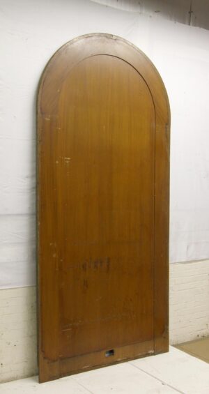 Arched wood panel section in a dark wood tone, shown upright with a tall rounded top and a small rectangular cutout near the bottom.
