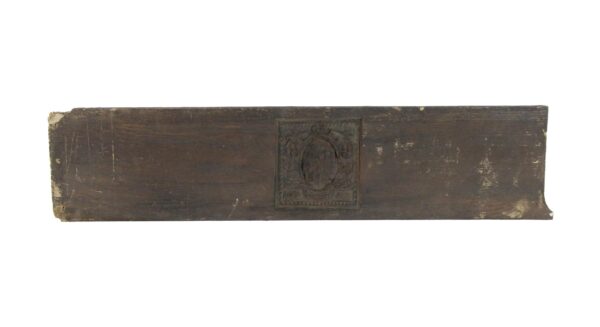 Arts and Crafts brown pediment with a centered coat of arms motif and visible age wear.