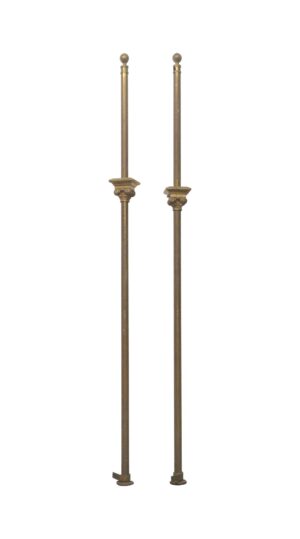 Pair of antique bronze posts with Gothic details shown standing side by side.