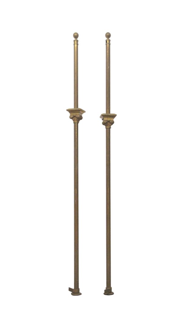 Pair of antique bronze posts with Gothic details shown standing side by side.