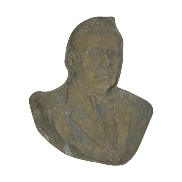 Bronze bust of a man in a tuxedo, shown from the front with visible surface wear.