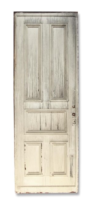 Antique five-panel white wood pocket door with original hardware and worn edges.