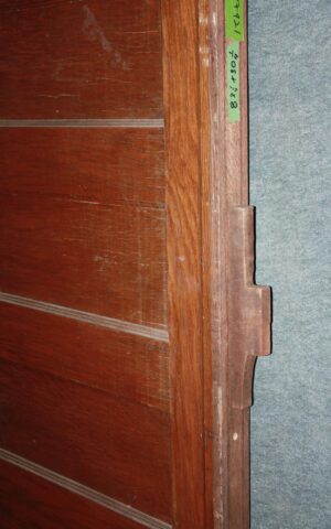 Antique six-pane wood pocket door with a dark wood tone, shown in close-up along the edge and panel detail.