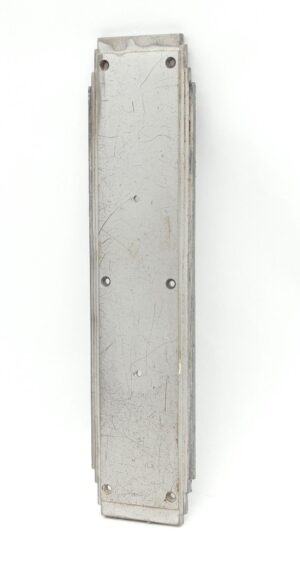 Vertical brushed aluminum door push plate with a rectangular Art Deco design, showing mounting holes and visible surface scratches on the back side.