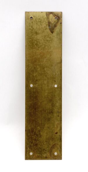 Vertical pressed brass door push plate with four countersunk screw holes and visible age wear.