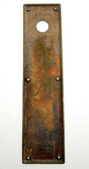 Vintage brass door push plate with a round lock insert opening and six mounting holes.