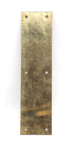 Vertical brass door push plate with four mounting holes and a worn polished brass finish.