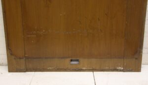 Dark wood tone mahogany panel section with visible wear and a small rectangular cutout near the bottom center.
