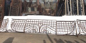 Art Nouveau wrought iron balcony with a central panel and curved side extensions displayed in sections.