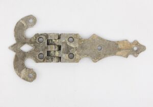 Antique ice box hinge with ornate cutout ends and multiple screw holes, shown in a closed position with visible surface wear and aged finish.