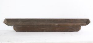 Carved mahogany door header with a long, stepped profile and visible egg-and-dart detail along the edge.