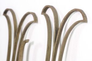 Close-up of antique brass Art Deco railing balustrades with curved tops and worn patina, shown in a set.