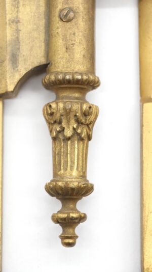 Close-up of a polished bronze door hinge with an ornate steeple tip and two knuckles.