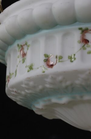 Close-up of a cast glass pendant light showing the scalloped rim and hand-painted pink flowers with green leaves and blue accents.