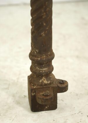Small cast iron corner post with a twisted spiral shaft and visible wear on the base.