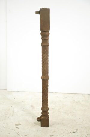 Tall cast iron corner post with a twisted spiral center section and worn surface, shown upright on a plain background.