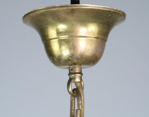 Close-up of a traditional brass lantern light with a flared top and hanging chain connector.