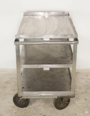 Three-tier service cart with a handle, open shelves, and casters, shown front on with visible scratches and dents.