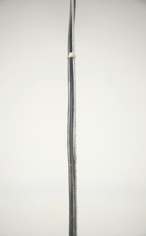 Close-up of a stainless steel pendant light cord and cable with a cable tie running vertically through the frame.