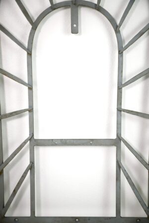 Gray wrought iron arched wall accent with leaf and vine details, shown front view with some rust visible near the joints and mounting holes.