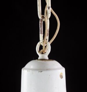 Close-up of a white schoolhouse pendant light showing the top of the milk glass shade, painted chain, and hanging loop with visible wear.