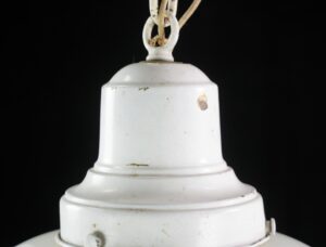 Close-up of a white schoolhouse pendant light showing the upper milk glass shade and white-painted chain connection.