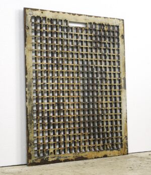 Rectangular cast iron wall grate with a grid of square openings and visible surface rust, shown in a straight-on view with two mounting holes.