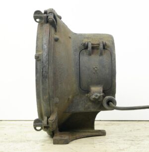 Industrial steel flood light with a hinged access panel, mounting bracket, and a power cord visible on one side.