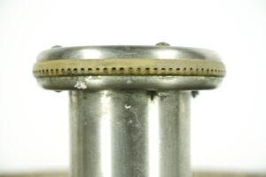 Close-up of a reclaimed hand wash fountain showing the top rim and cylindrical metal body with visible wear and a perforated band around the middle.
