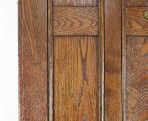 Close-up of an Arts & Crafts oak entry door with dark wood tone and visible paneled detailing.