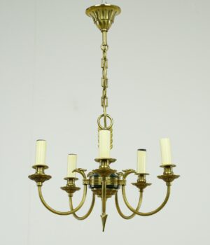 French Empire five-arm chandelier in antique brass with a central green accent and candelabra-style candle sleeves.