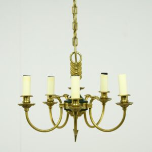 French Empire five-arm chandelier with brass frame, green central accent, and candelabra-style candle sleeves.