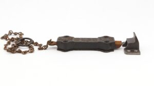 Victorian cast iron surface door bolt with chain, shown with the bolt, chain loop, and separate keeper bracket.