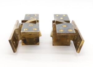 Pair of polished brass pocketed pivot door hinges shown as a matching set, with drilled mounting plates and visible age wear on the metal surfaces.