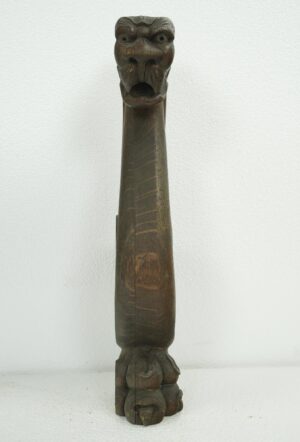Dark wood tone pine snake carving with a long carved body and a face at the top, shown from the front.