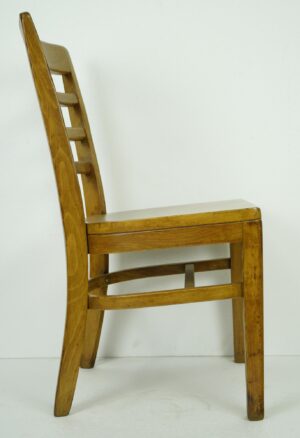 Side view of a wood chair with a slatted back and medium wood tone finish.