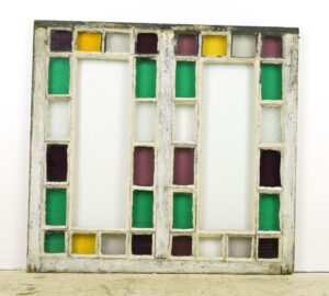Antique Queen Anne stained glass window with a weathered white pine frame and a grid of clear and multicolor panes.